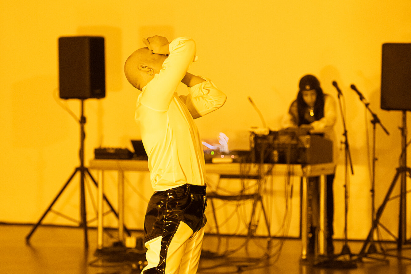 canaer teker in gelbem Licht mit DJ Pult im Hintergrund