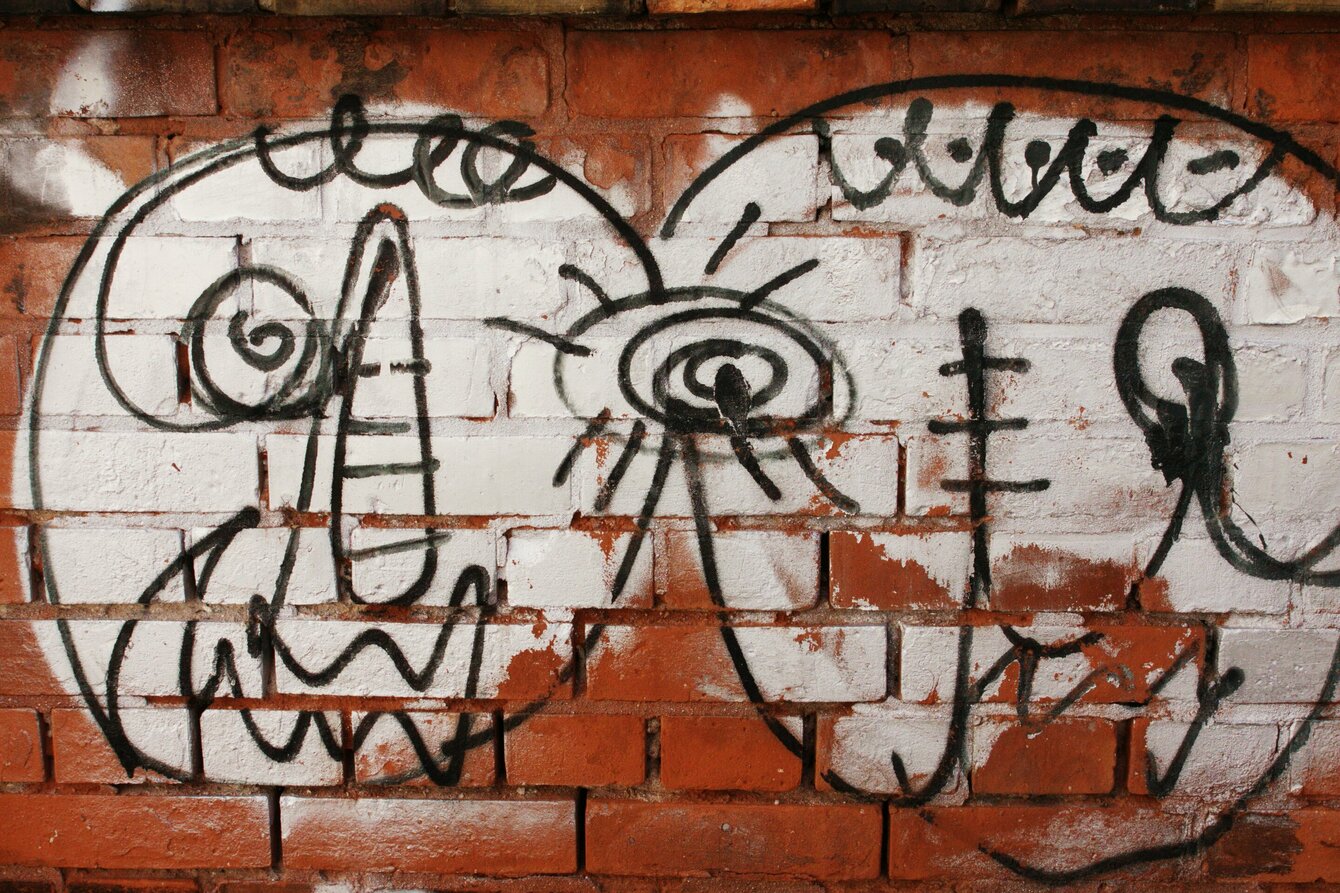 Eine rote Backsteinwand mit Graffiti
