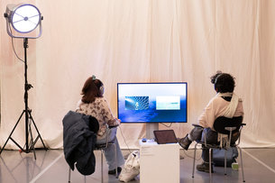 JUNCTIONS Ausstellungsansicht, zwei Personen schauen auf einen Screen 