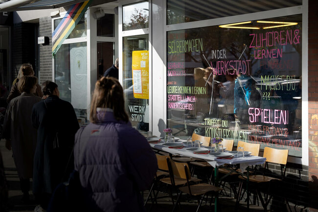 Menschen stehen vor der WerkStadt in Essen-Katernberg und unterhalten sich