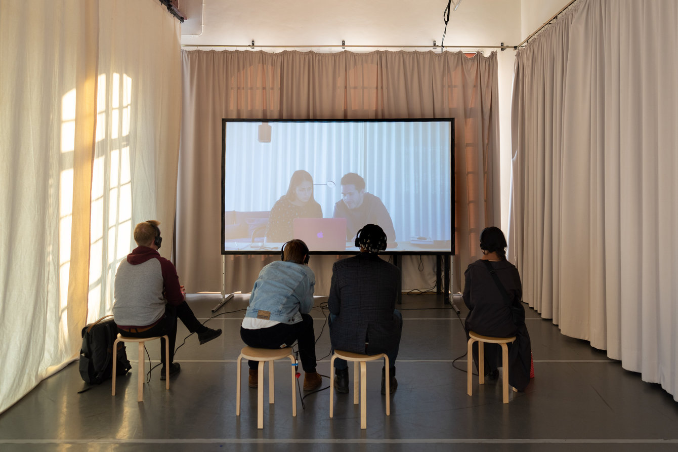 Besucher:innen schauen das Video von Ellen Lapper