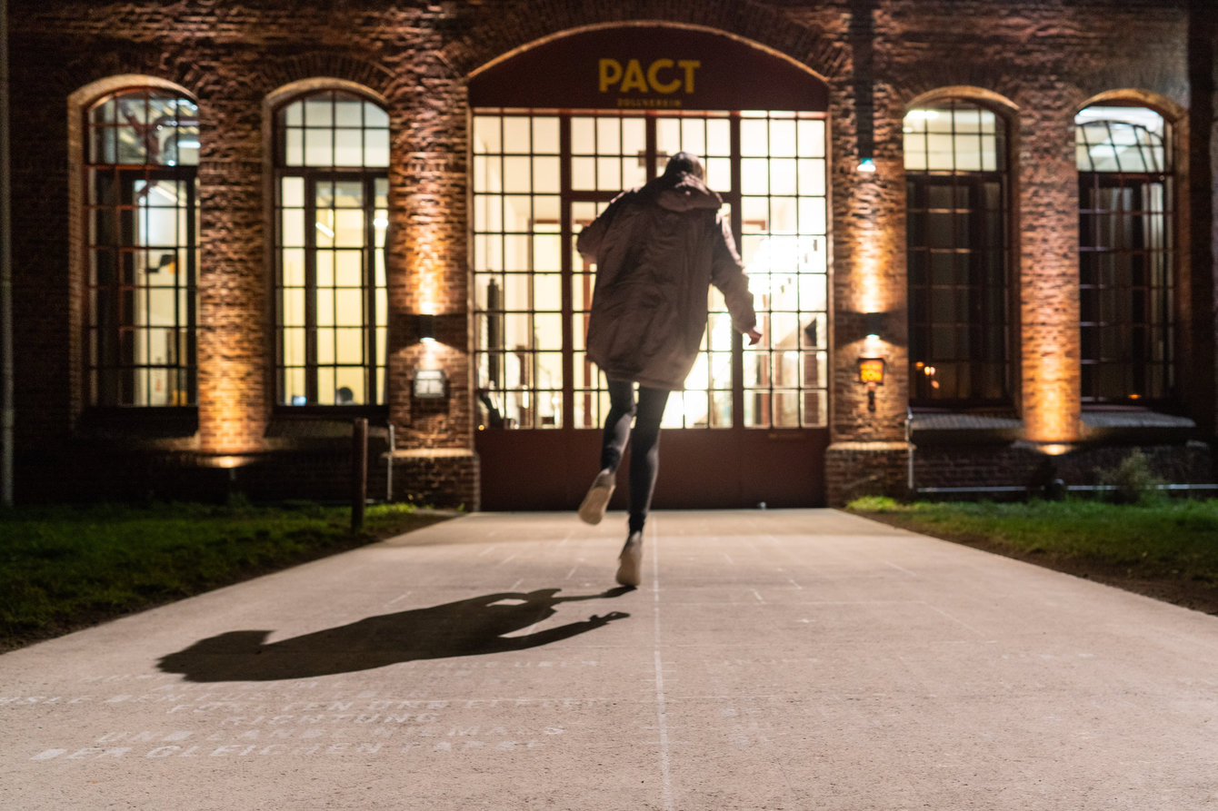 Eine Person springt über die eingezeichneten Linien von Himmel & Hölle