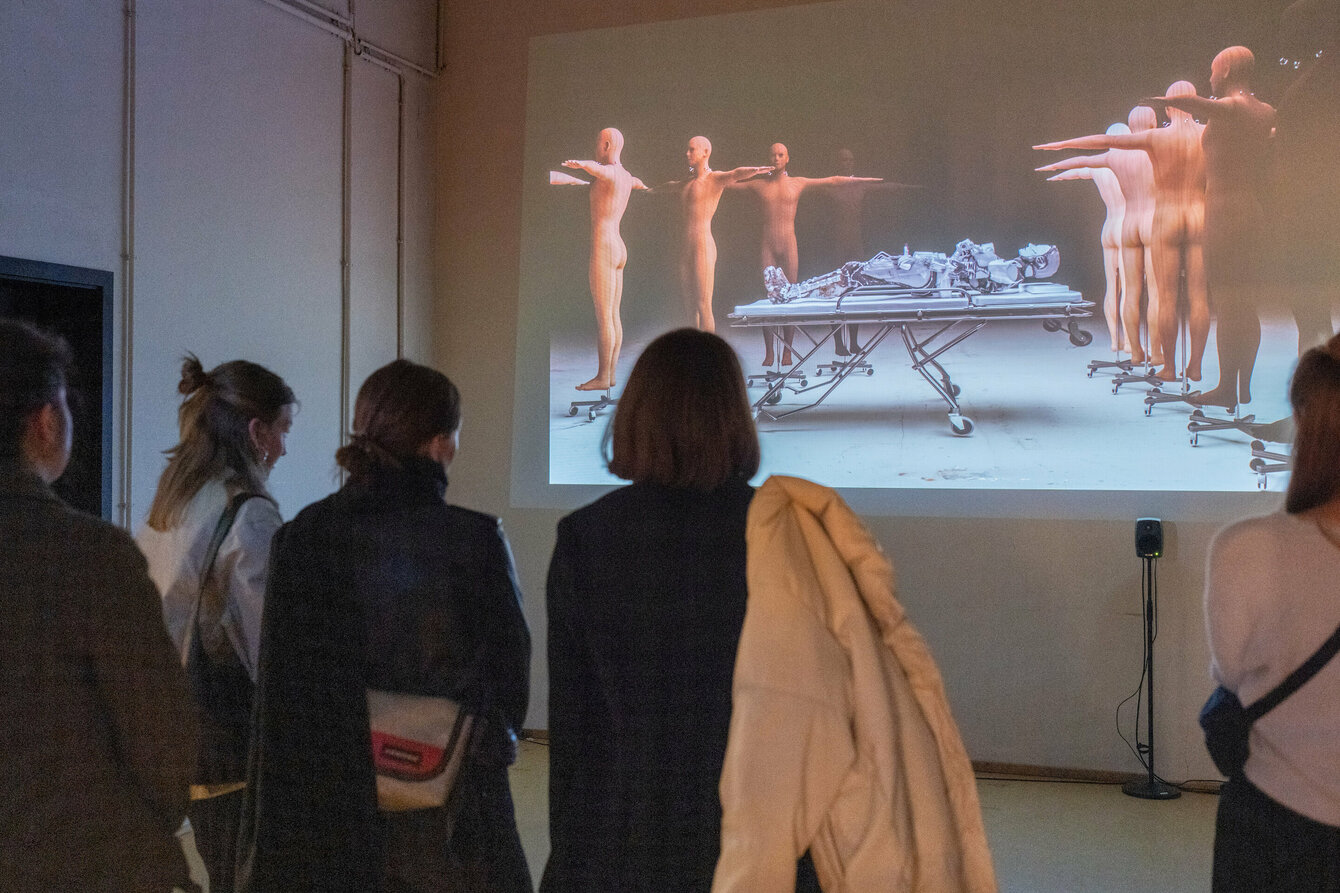 Besucher:innen von hinten vor einer Videoinstallation 