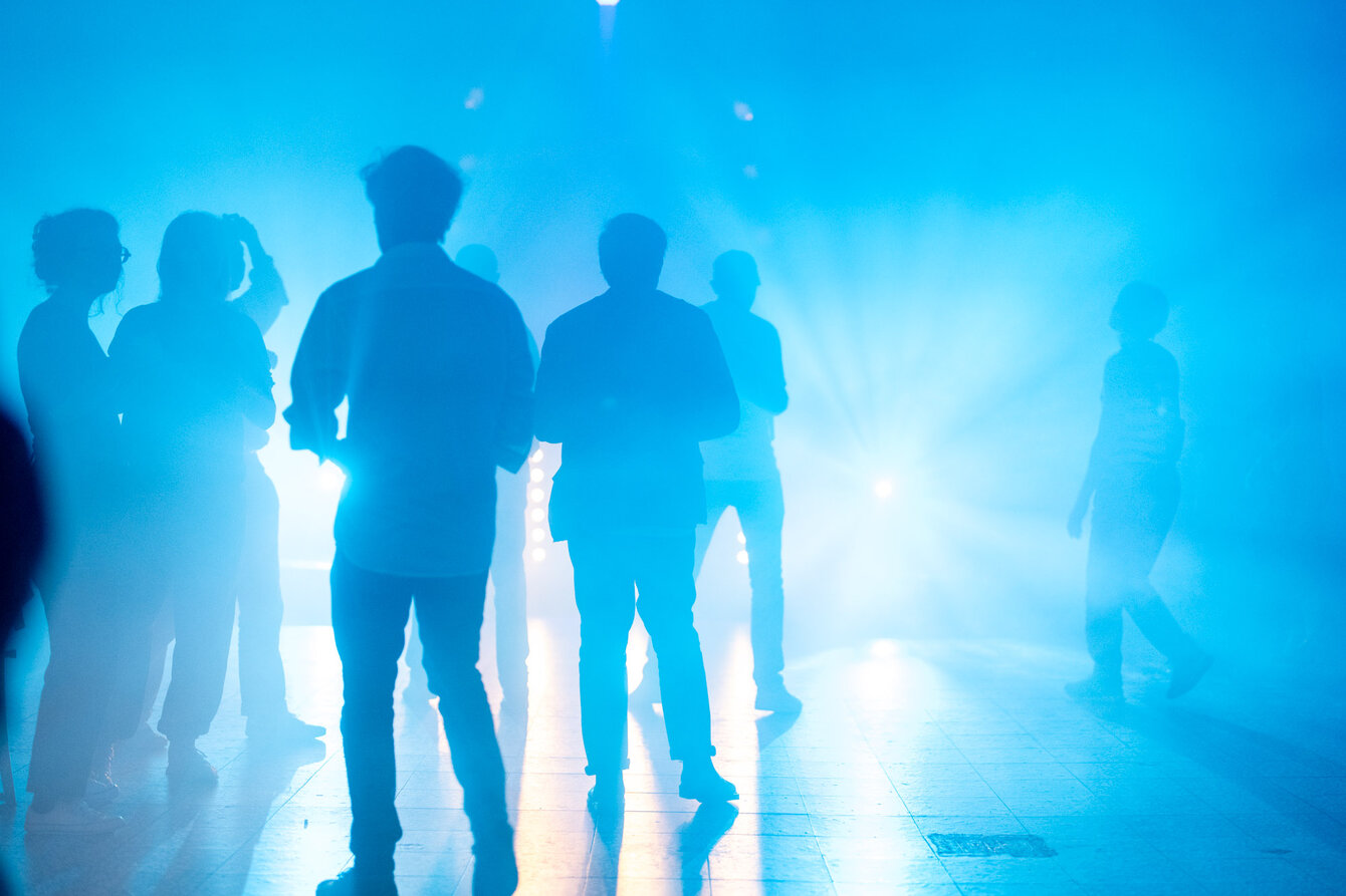 Eine Gruppe tanzender Menschen in blauem Licht