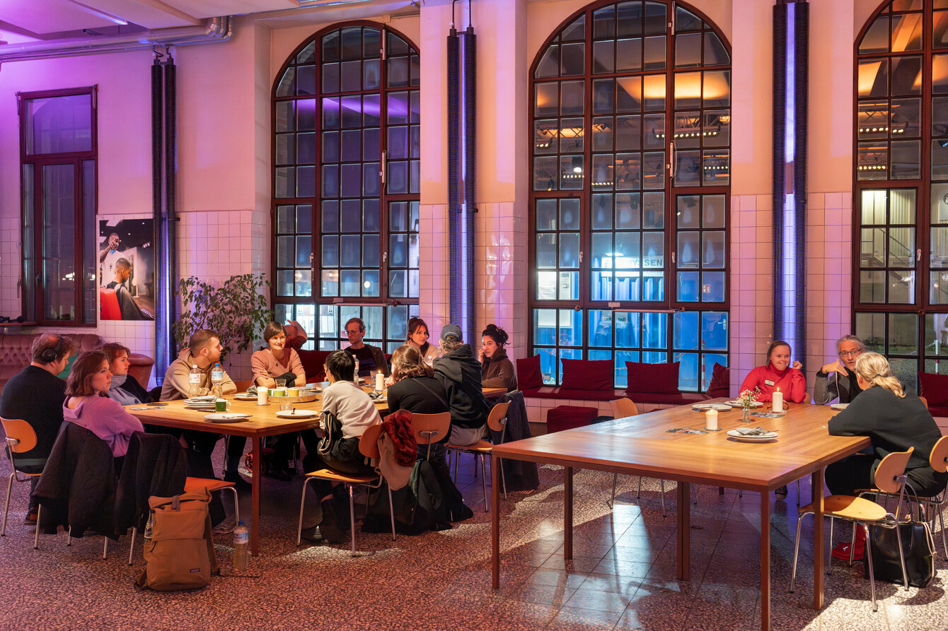 Menschen sitzen an Tischen im Foyer