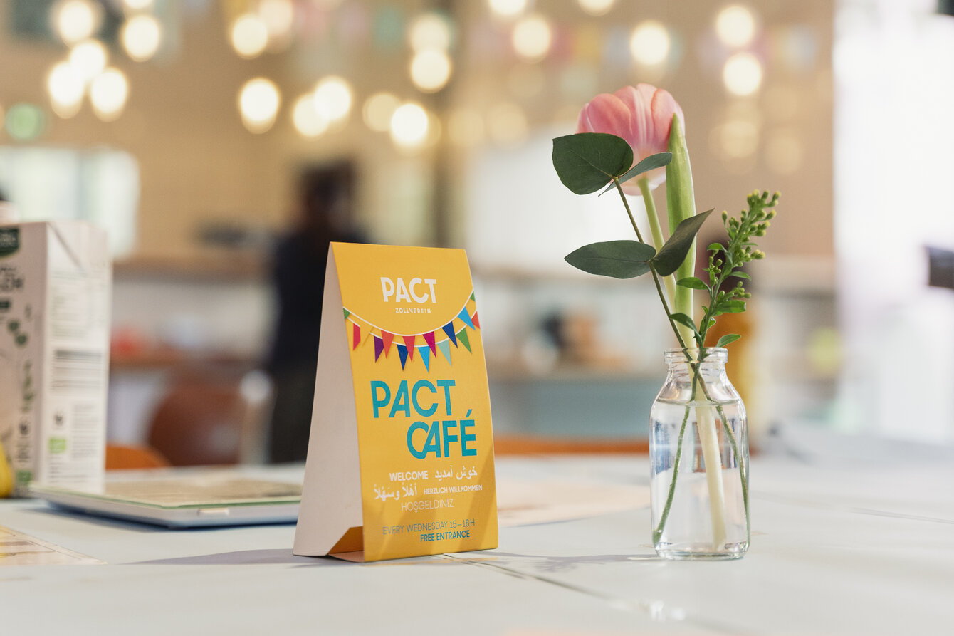 Tischaufsteller mit dem Schriftzug PACT Café