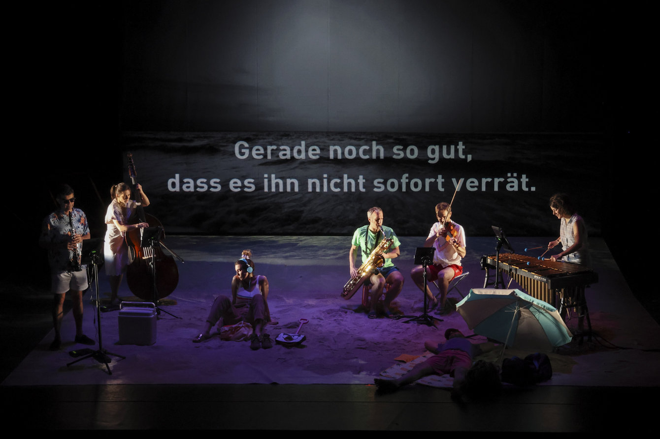 Musiker auf einer Bühne, im Hintergrund Schriftzug: Gerade noch so gut, dass es ihn nicht verrät