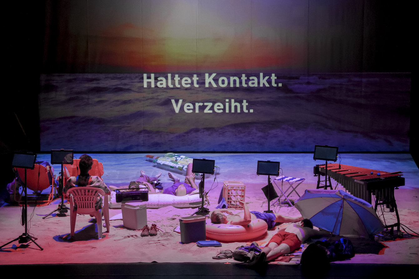 Strand mit Liegestühlen, Sonnenschirmen, Menschen liegen, im Hintergrund Schriftzug: Haltet Kontakt, verzeiht