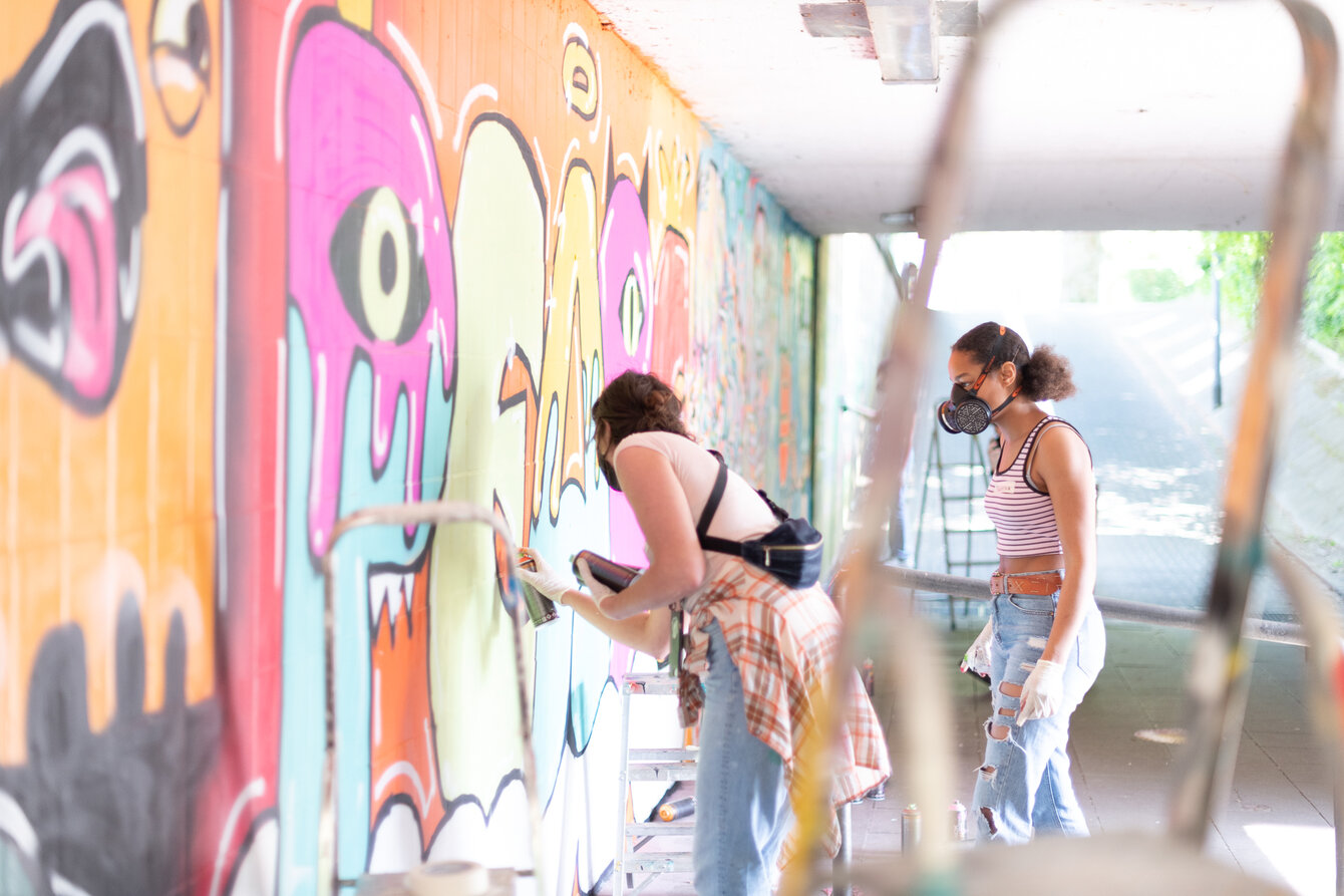 Kinder beim bemalen einer Graffitit-Wand in Essen Katernberg