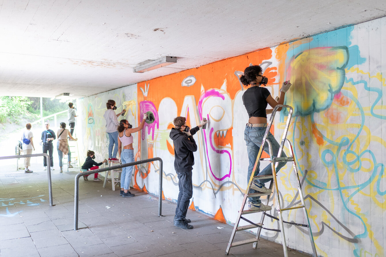 Kinder beim bemalen einer Graffitit-Wand in Essen Katernberg