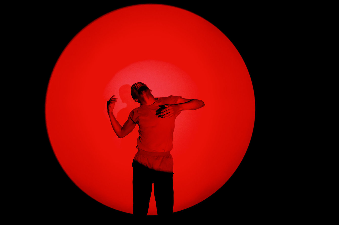 Wezile Harmans performing in front of a round red light