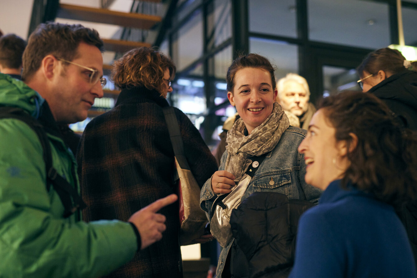 Lachende Menschen stehen in einer Gruppe zusammen