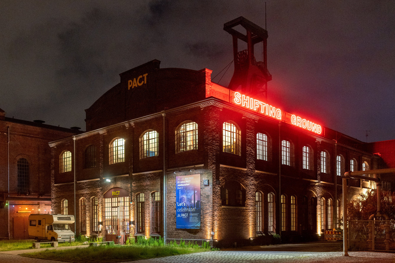 Der Schriftzug Shifting Ground auf dem Dach von PACT Zollverein bei Nacht