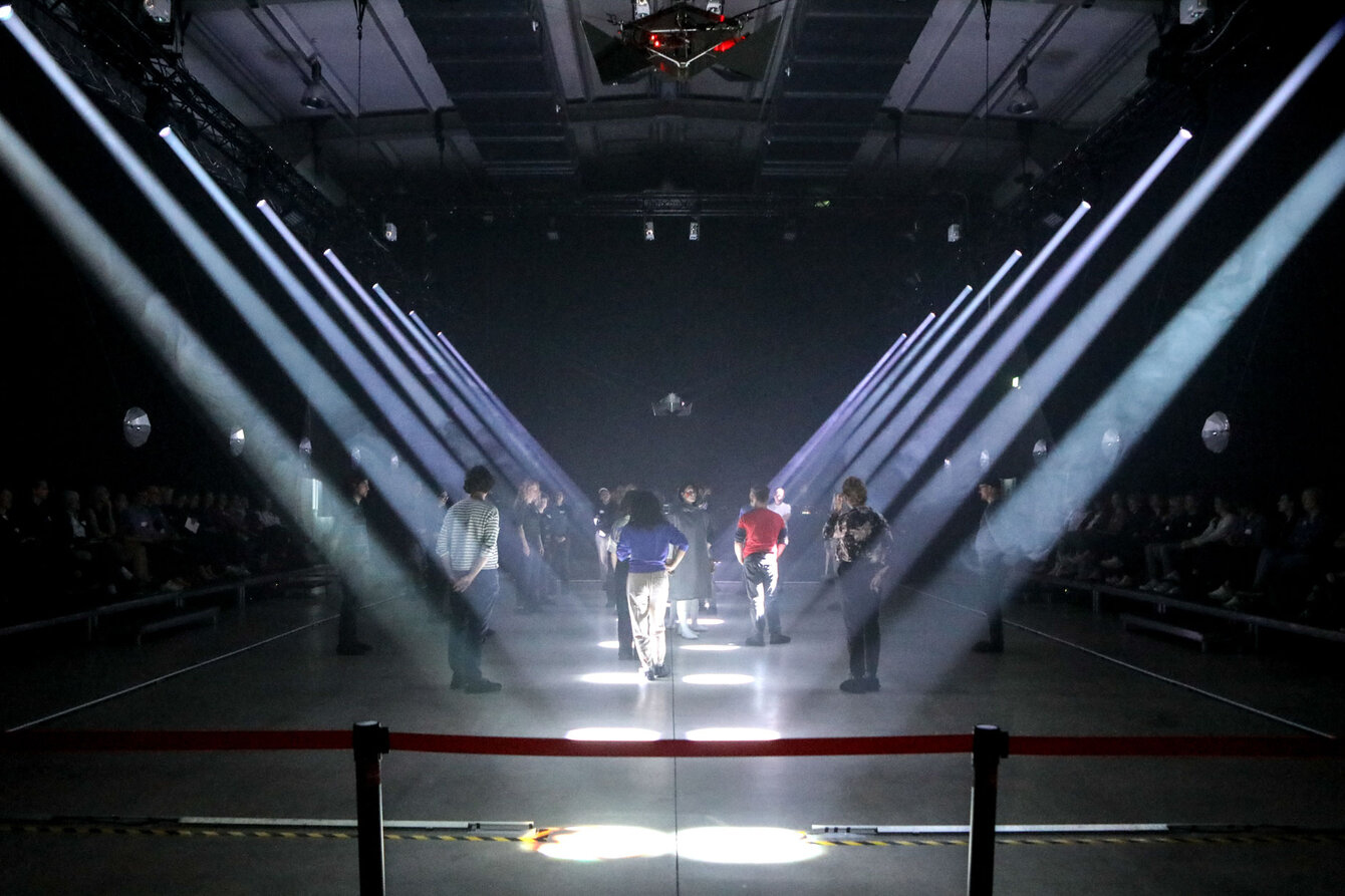 Stage with several cones of light falling on the performers