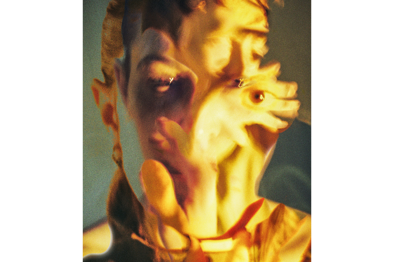 Ein gelb-grün eingefärbtes, abstrahiertes Portrait einer Person. Die rechte Gesichtshälfte wird von einer Hand bedeckt, auf der unter anderem ein Auge zu sehen ist. Das Gesicht und die Hand scheinen ineinander zu verlaufen.