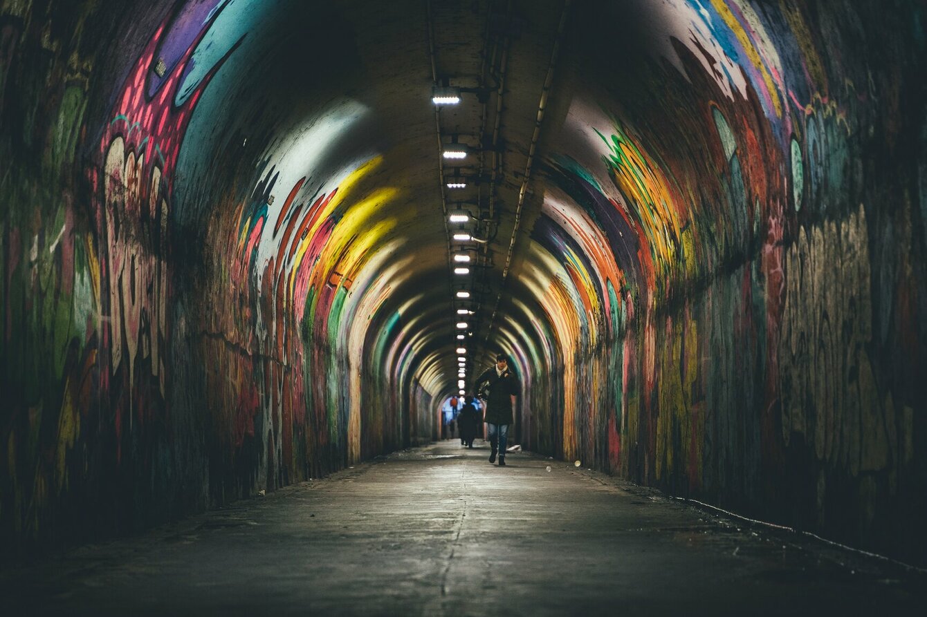 Ein dunkler Tunnel mit Graffiti an den Wänden