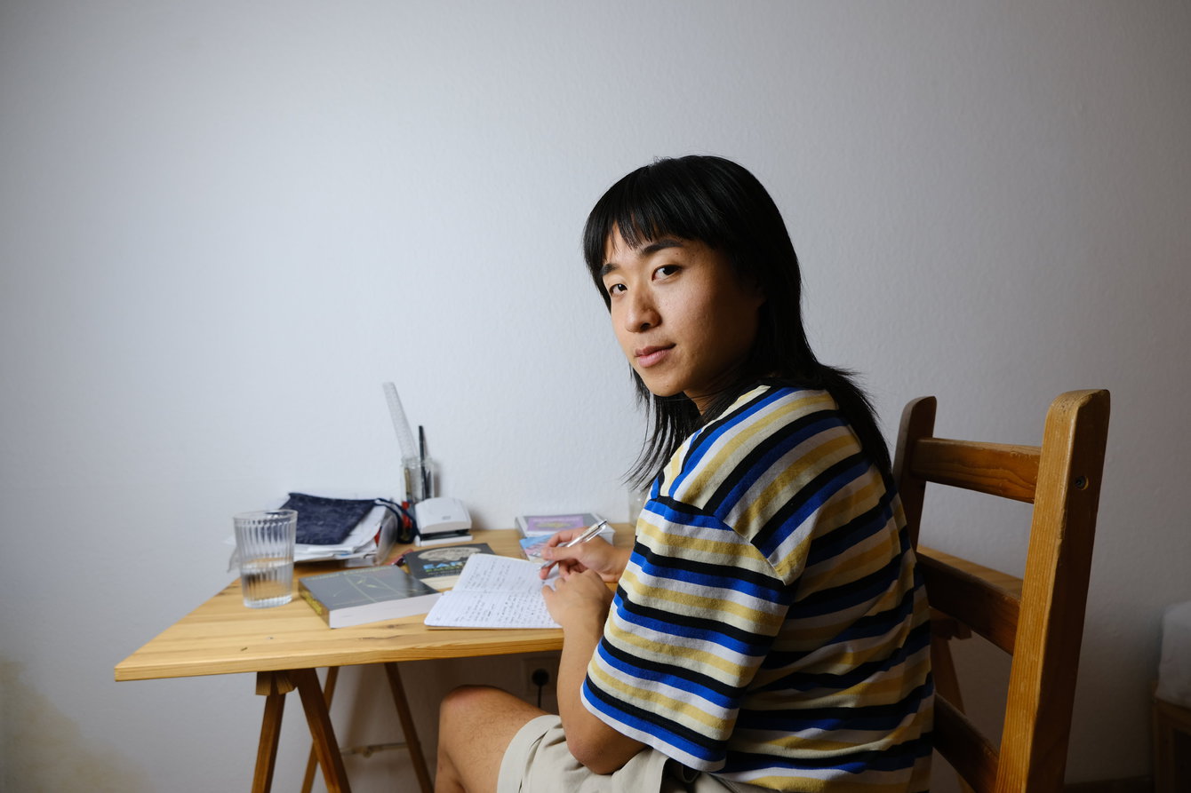 Paula Pau poses for the camera while taking notes for her research ›Eco Queerness‹.