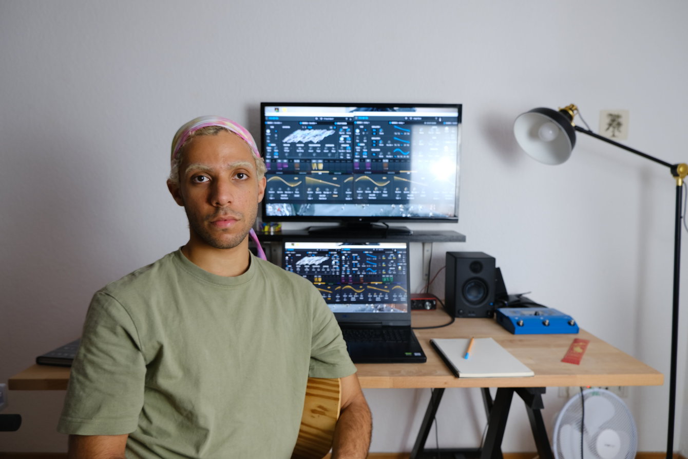 Igor Meneses poses at their bedroom studio while exploring sound design during their #TakeCare residency