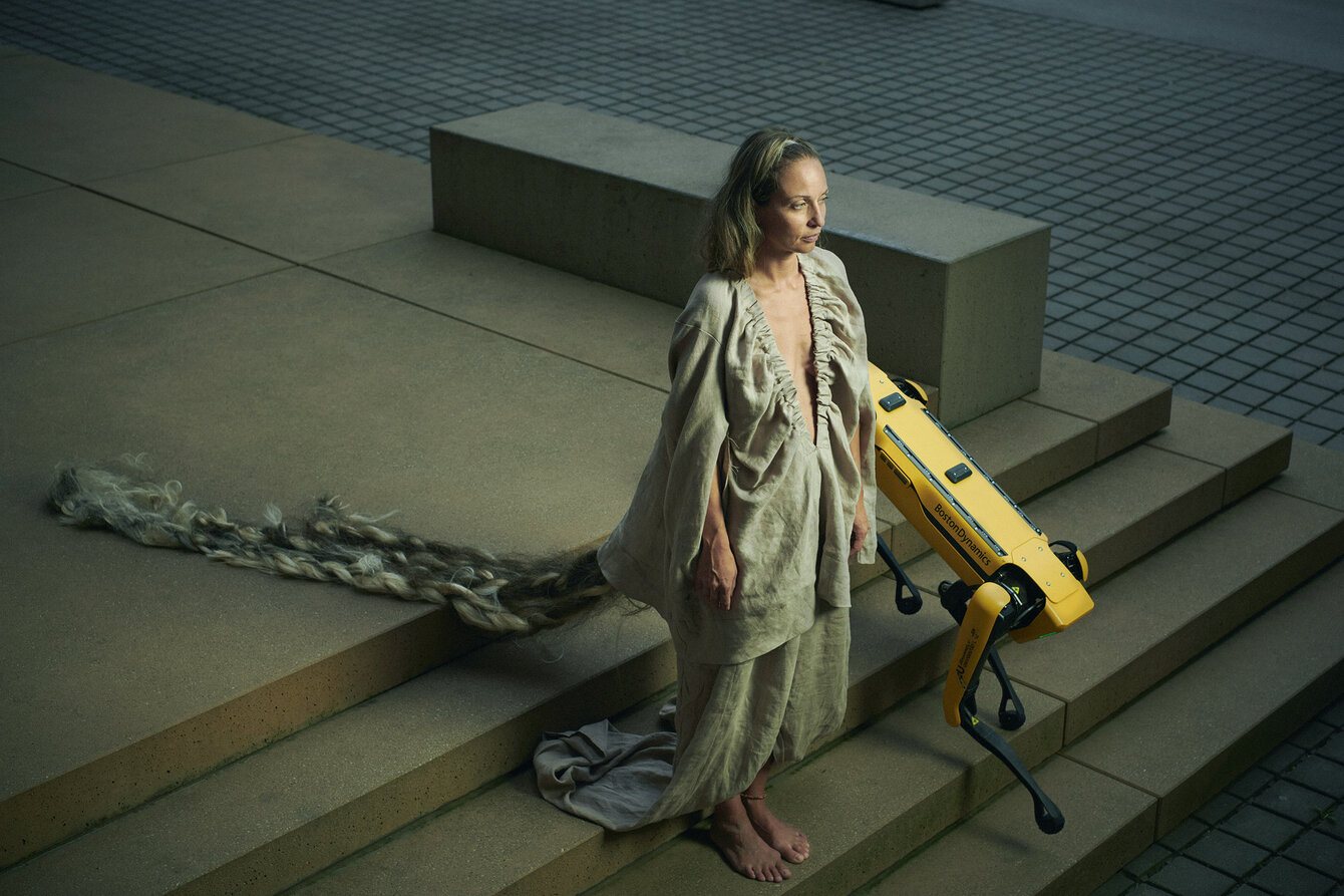 Silke Grabinger mit Roboterhund auf einer Treppe 