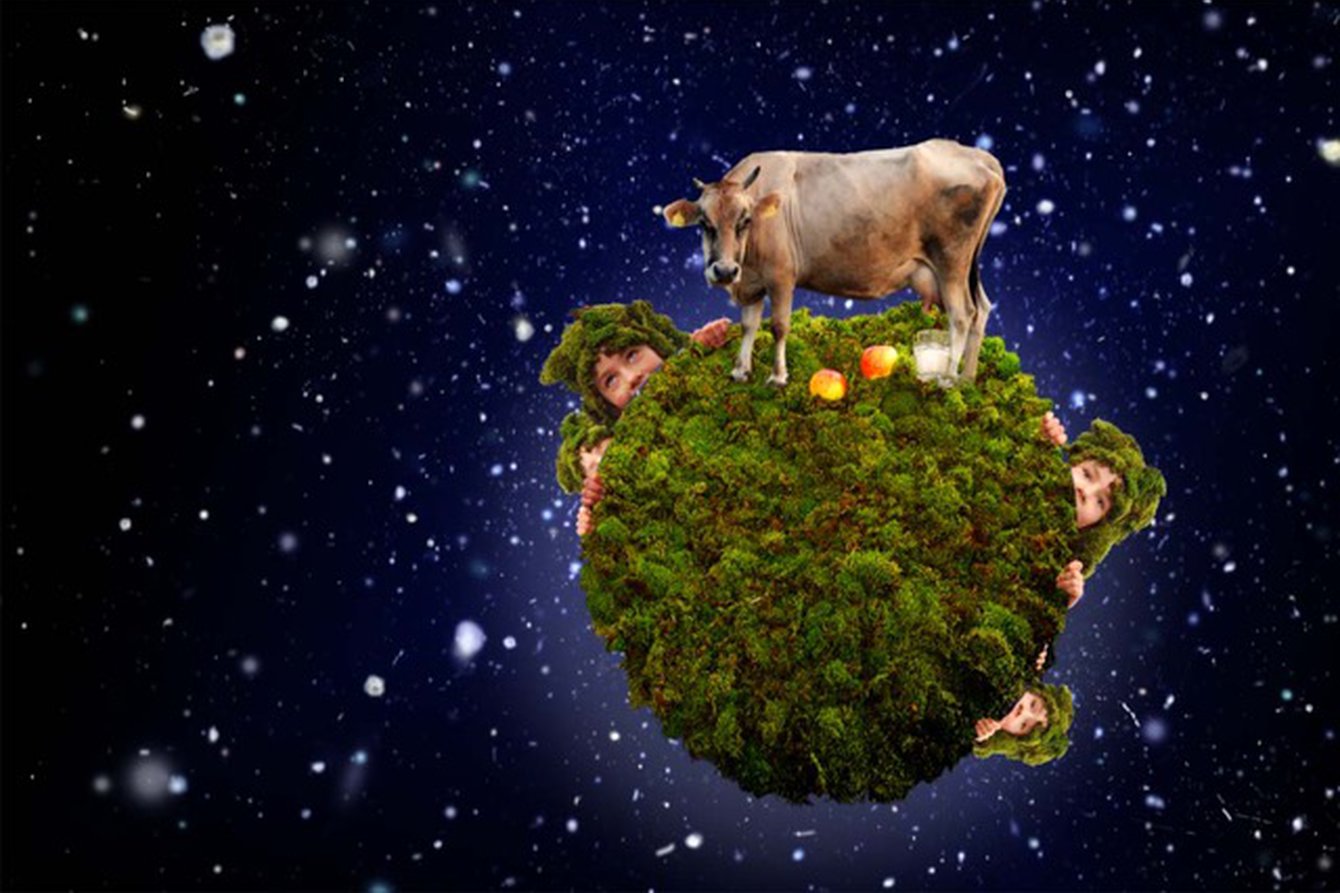 Die Erde im Weltall. Vergrößert sind eine Kuh und drei Gestalten zu sehen.