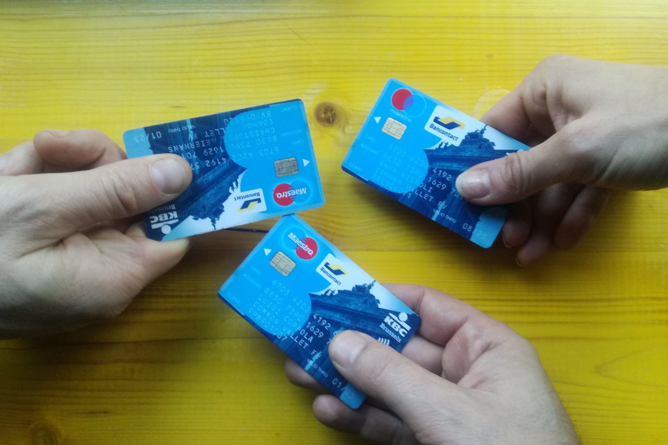 Es werden drei Kreditkarten ins Bild gehalten, die dieselbe IBAN haben.