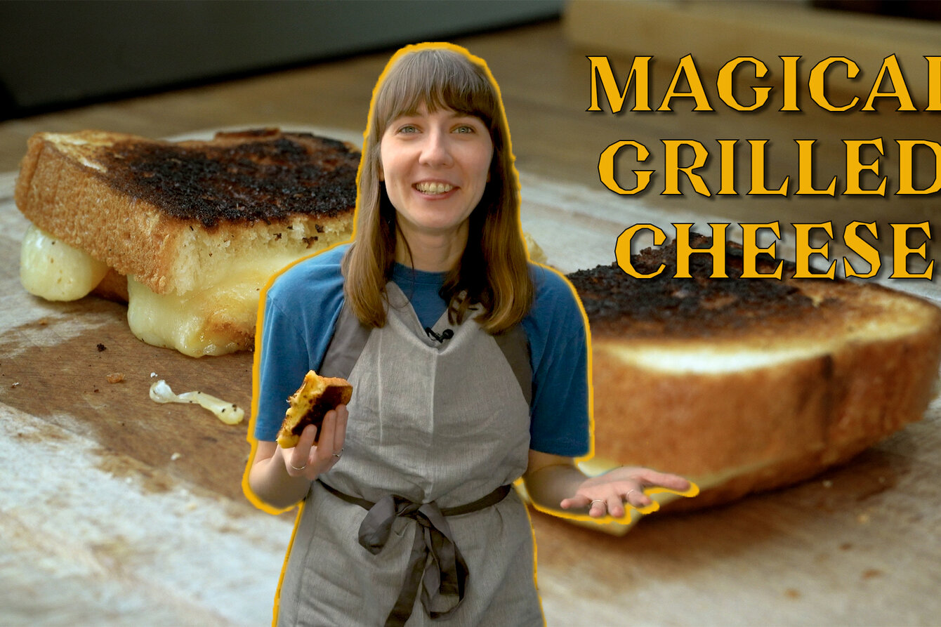 Bild im Stile eines Youtube-Thumbnails: Dasha Ilina posiert freigestellt mit einem Käsesandwich und Küchenschürze. Hinter ihr eine Nahaufnahme von Käse-Sandwiches, neben ihr der Name des Video: Magical Grilled Cheese.