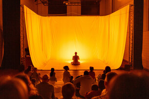 Bühnenraum mit Kindern vor einem gelb leuchtenden Tuch
