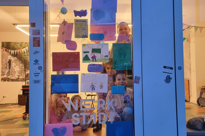 Kinder dekorieren das Schaufenster der WerkStadt