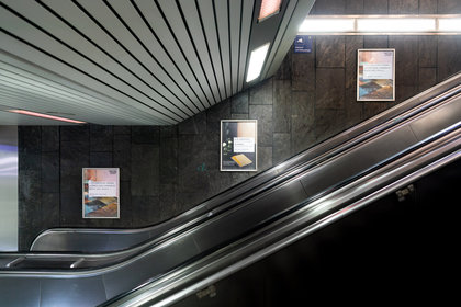 Plakate hängen an der Rolltreppe zur U-Bahn Station