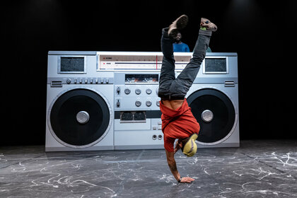 Tänzer auf der Bühne im Handstand