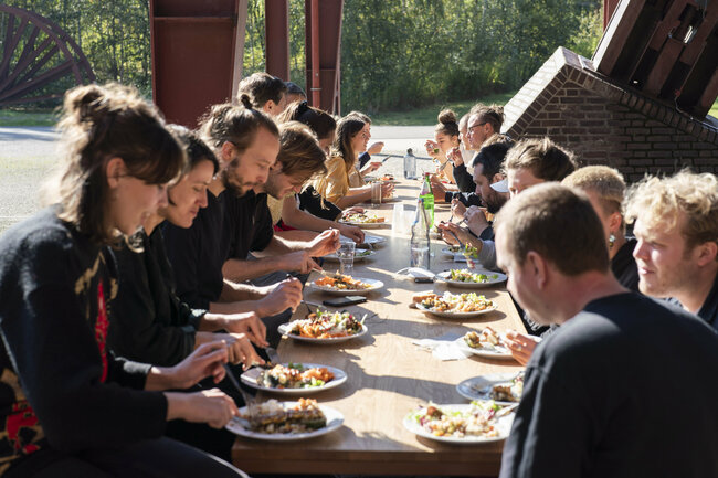 Eine Gruppe Menschen sitzt an einer langen Tafel