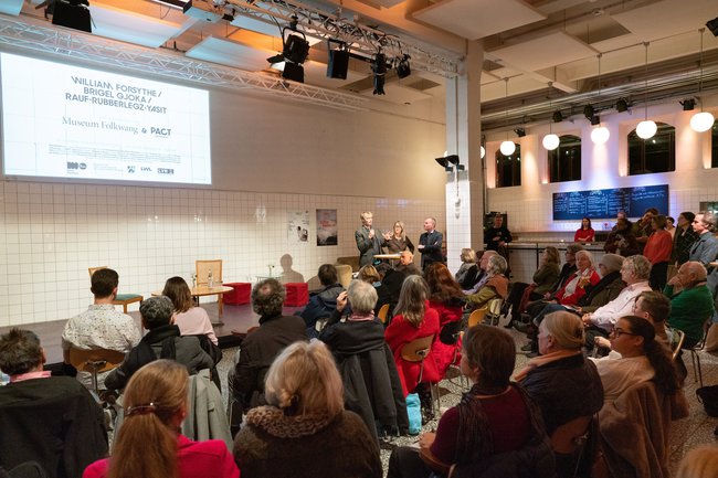 Lecture situation in the foyer with bar in the background