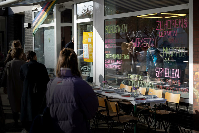 Personen stehen vor dem Schaufenster der WerkStadt